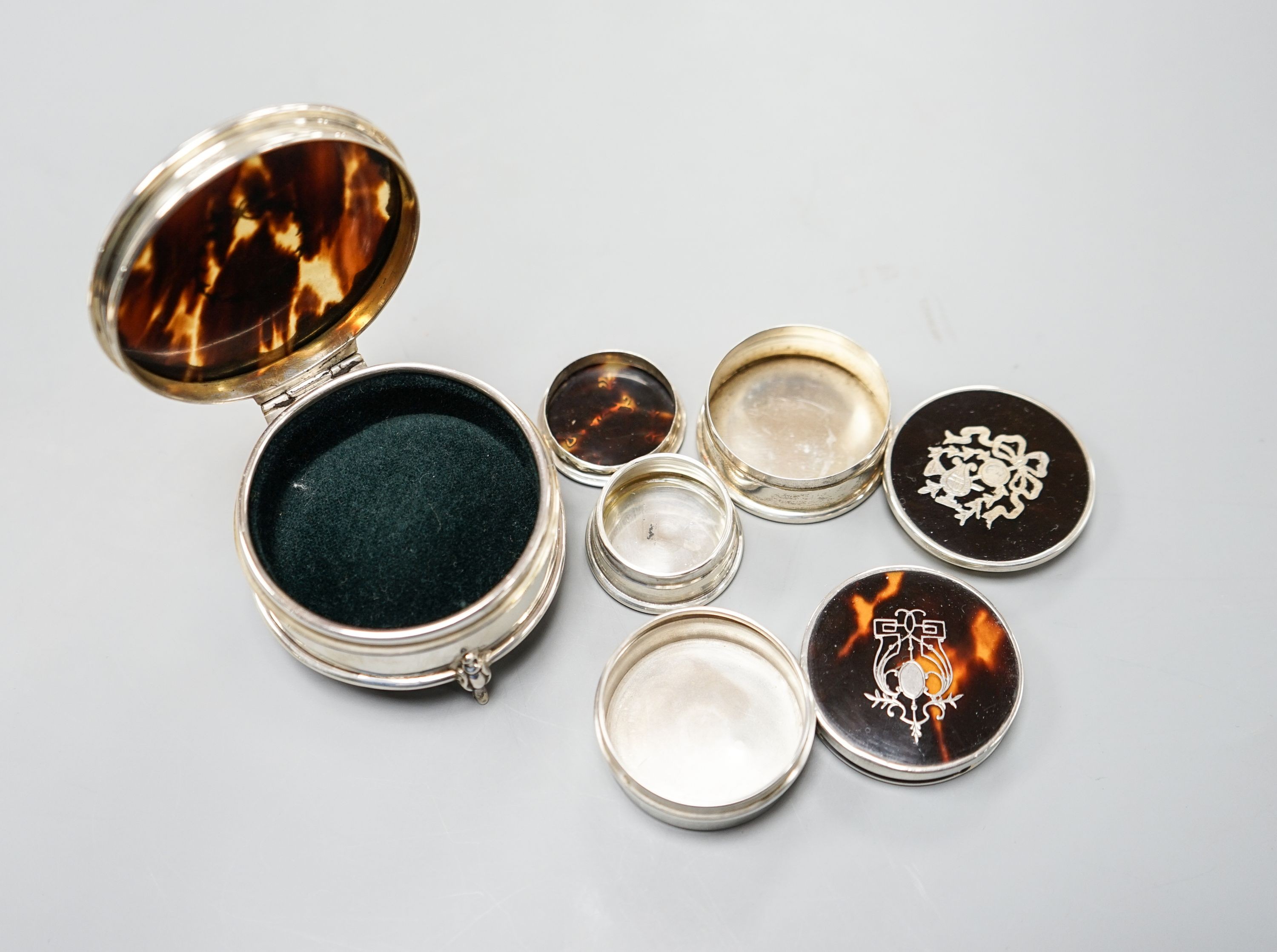 A George V silver and tortoiseshell pique circular trinket box, Birmingham, 1923, 61mm and three other similar smaller boxes and covers.